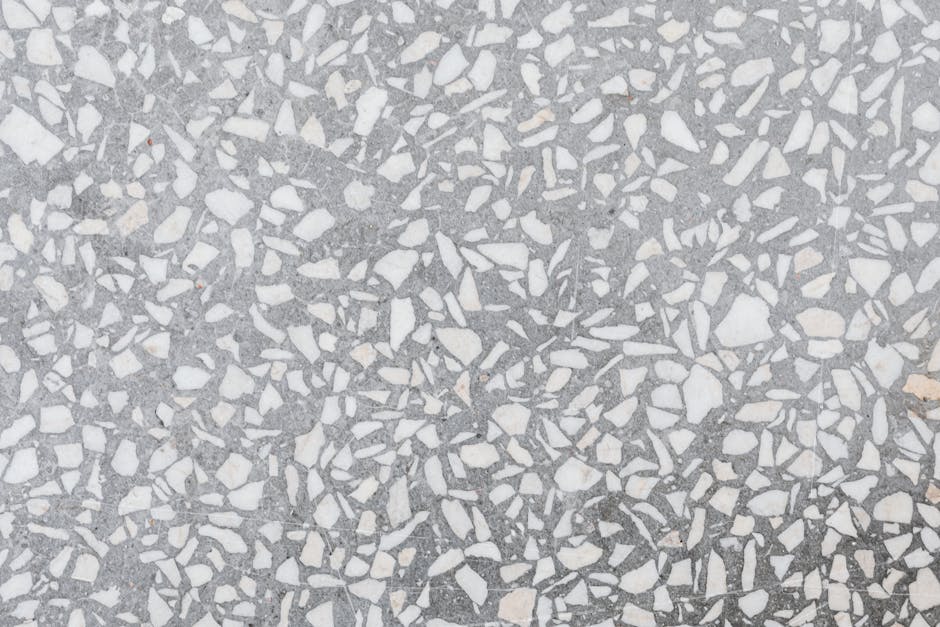 Een expert repareert een beschadigde terrazzo vloer met zorg en precisie.